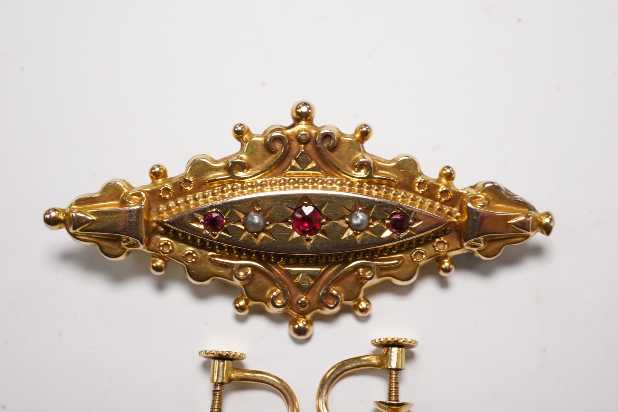 A pair of antique yellow metal, amethysts and seed pearl set drop earrings, 22mm and a Victorian 9ct, ruby and split pearl set brooch, gross weight 6.6 grams. Condition - fair to good